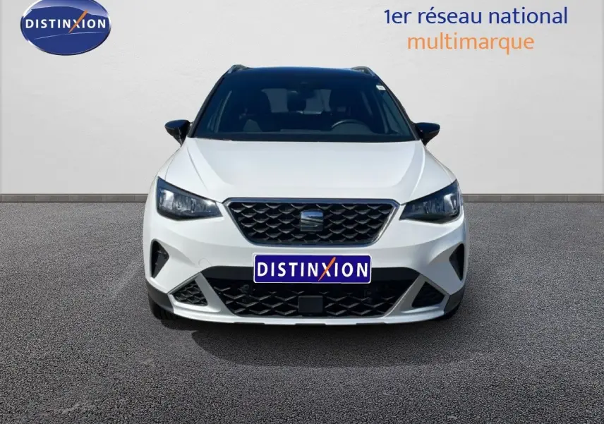 Vue avant d'un SEAT Arona blanc avec toit noir, calandre noire et phares LED, sur fond neutre.