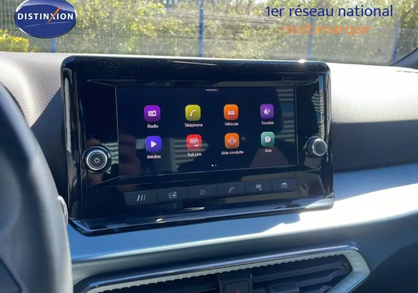 Vue intérieure centrée sur l’écran tactile du tableau de bord du SEAT Arona 2025, ambiance lumineuse naturelle.