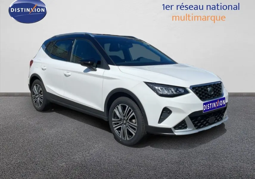 SEAT Arona 2025 blanc toit noir en 3/4 avant droit, avec jantes alliage et calandre noire distinctive.