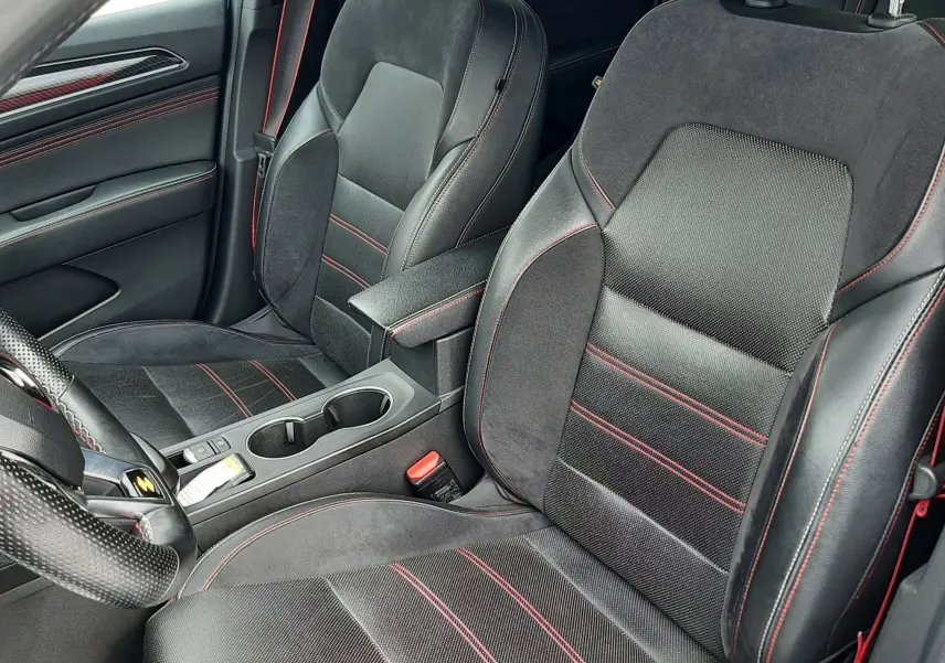 Vue intérieure rapprochée des sièges avant noirs avec surpiqûres rouges du Renault Arkana E-Tech 145ch RS-Line 2021.