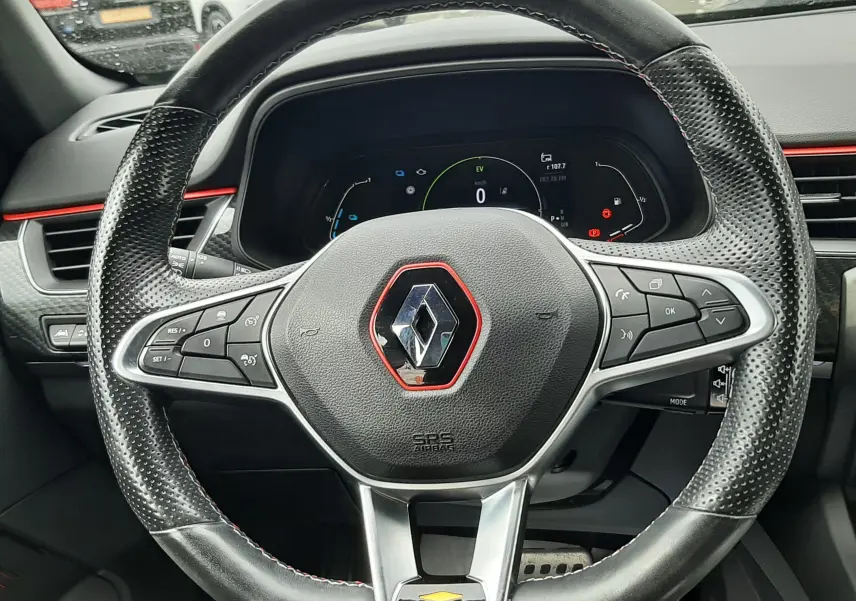 Vue rapprochée du volant cuir perforé avec logo Renault rouge du tableau de bord du Renault Arkana E-Tech 145ch.