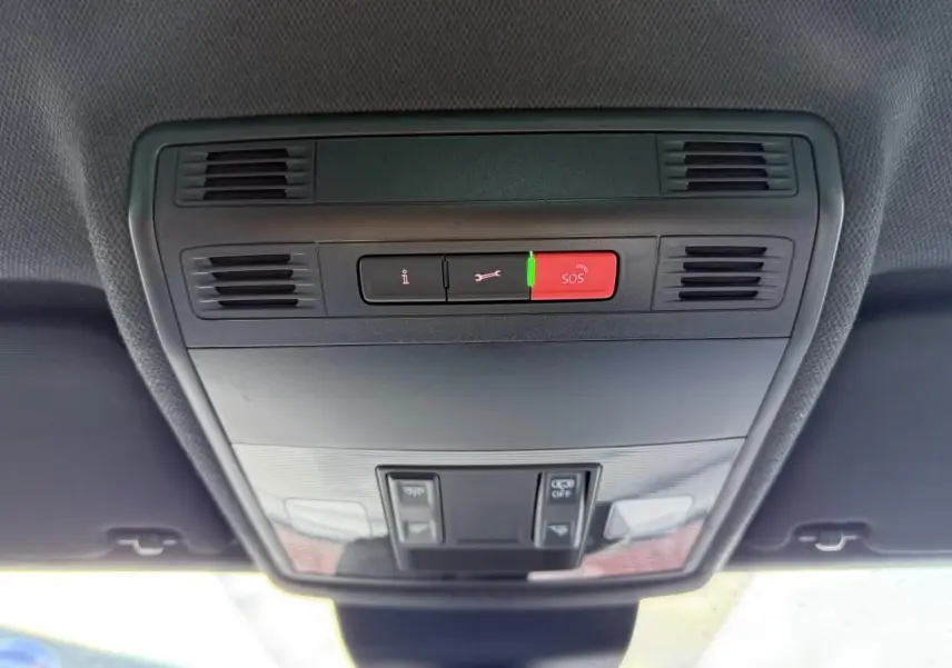 Vue en gros plan du plafonnier intérieur noir avec bouton SOS rouge et commandes d'éclairage du SEAT Arona 2024.