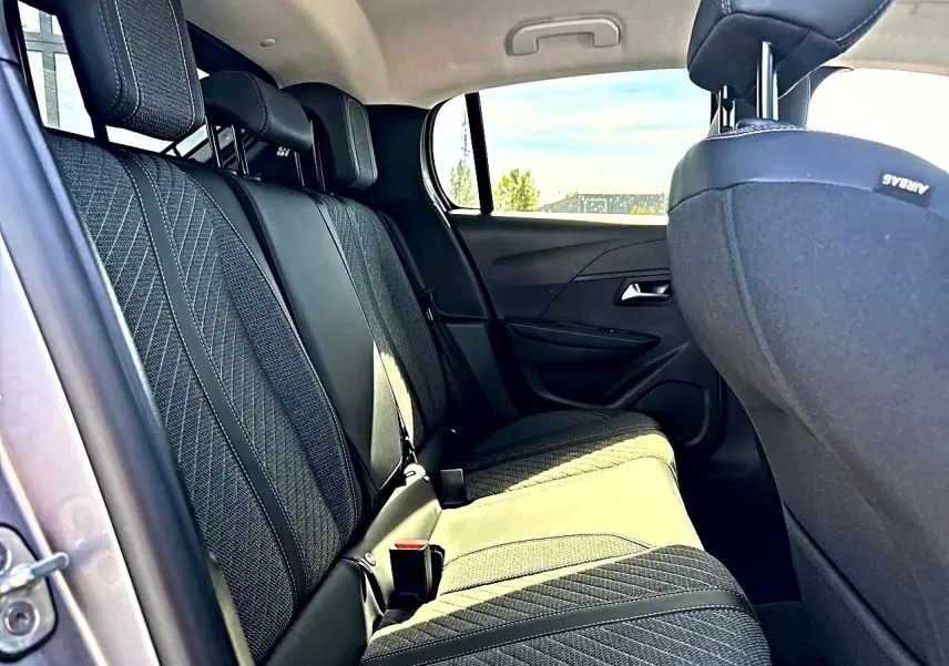 Vue intérieure côté gauche sur la banquette arrière tissu gris avec appuie-têtes et ceintures visibles dans une Peugeot 208 2025.