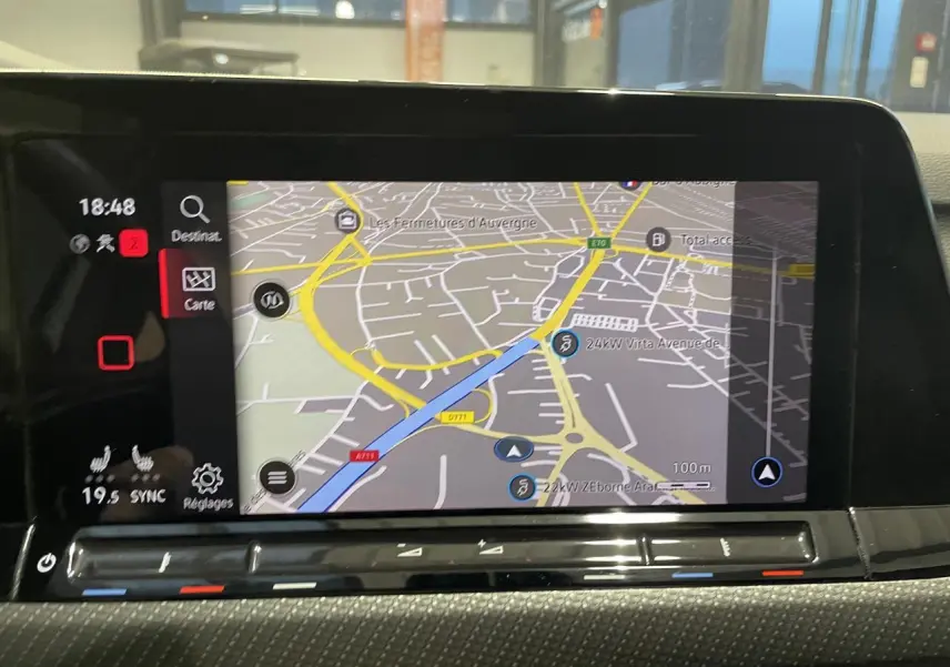 Écran tactile central affichant la navigation GPS dans l'habitacle d'une Volkswagen Golf VIII blanche.