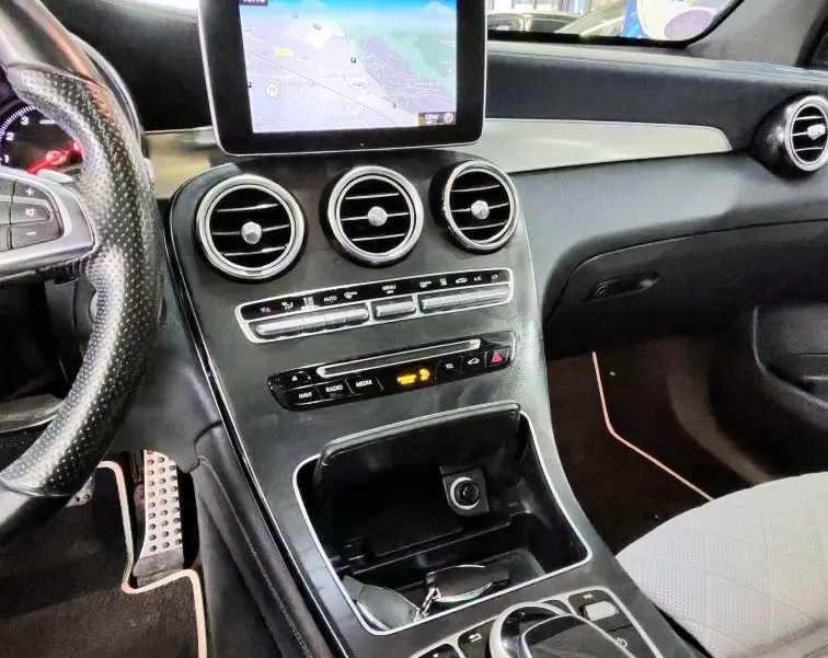 Vue intérieure de la console centrale et tableau de bord du Mercedes GLC Coupé noir avec écran GPS et commandes tactiles.