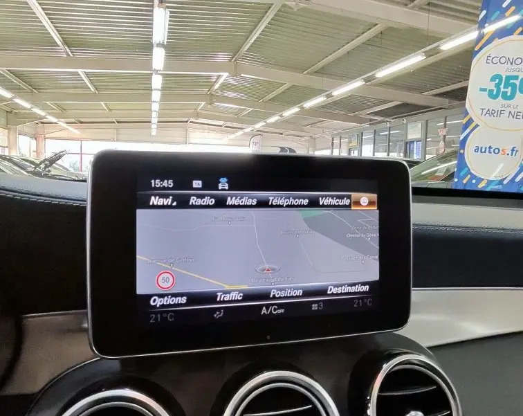Vue rapprochée de l’écran central multimédia et des aérateurs ronds chromés de la Mercedes GLC 350 Coupé noire.