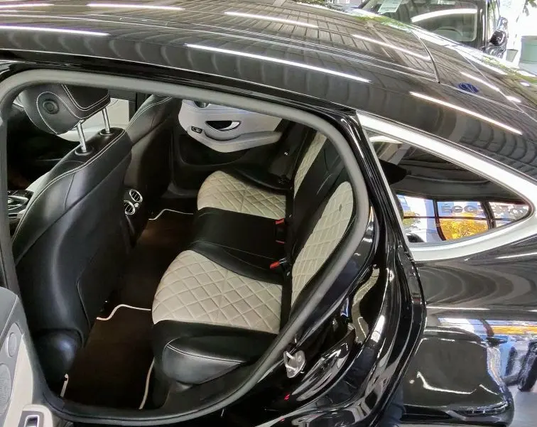 Vue côté arrière gauche du Mercedes GLC Coupé noir, mettant en valeur l'intérieur cuir bicolore et les sièges arrière élégants.