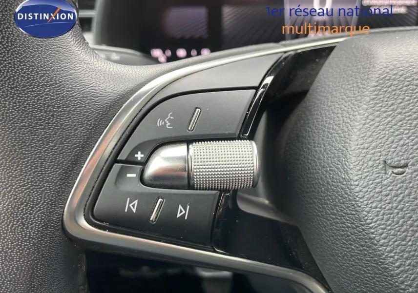 Gros plan sur les commandes multimédia au volant en cuir noir d'une Skoda Kamiq rouge Velvet Metal 2024.