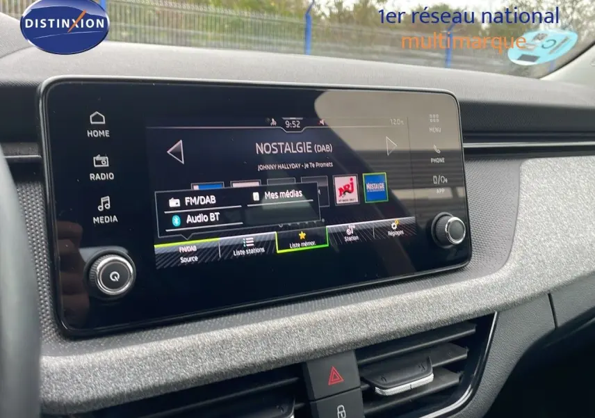 Écran tactile central du Skoda Kamiq 2024 affichant la radio DAB, avec tableau de bord gris et commandes visibles.