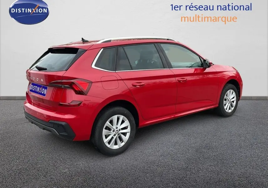 Vue 3/4 arrière droite d'un Skoda Kamiq rouge Velvet Metal avec jantes alliage et toit blanc contrasté.