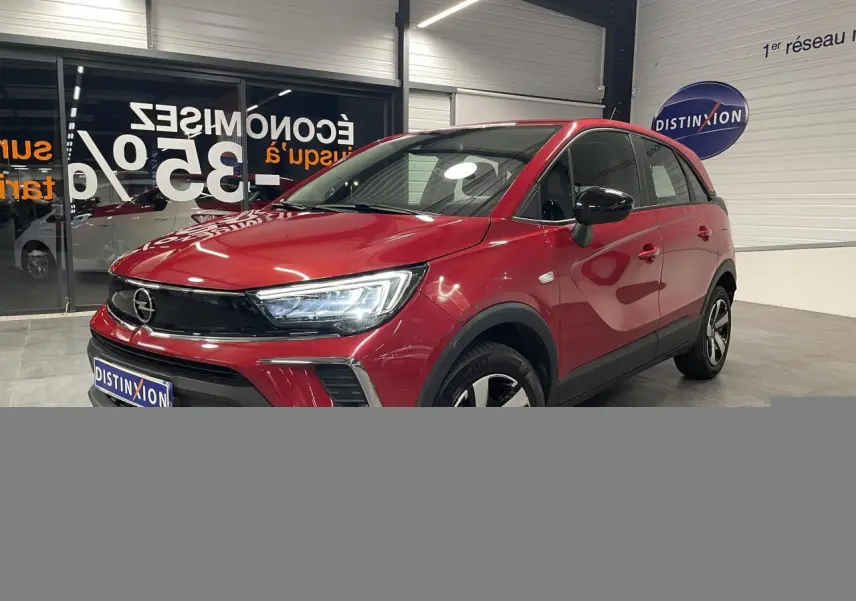 Opel Crossland rouge clair vue 3/4 avant droit, avec calandre noire et jantes bicolores 16 pouces.