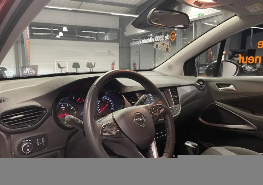 Vue intérieure côté conducteur de l’Opel Crossland 2022, volant cuir multifonction et tableau de bord avec écran tactile.