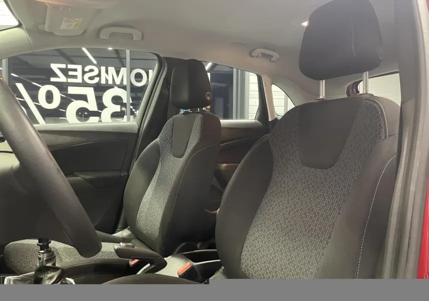 Vue intérieure des sièges avant en tissu noir et gris de l’Opel Crossland rouge clair, avec volant partiellement visible.