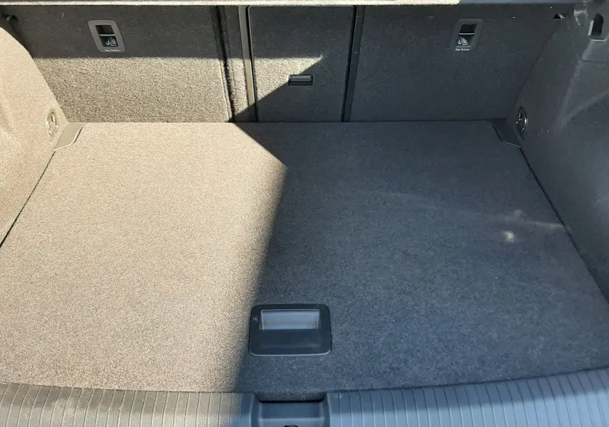 Vue intérieure du coffre spacieux et gris du Volkswagen T-Roc 2.0 TDI 150CH R-LINE DSG7 2024, avec revêtement tissu.