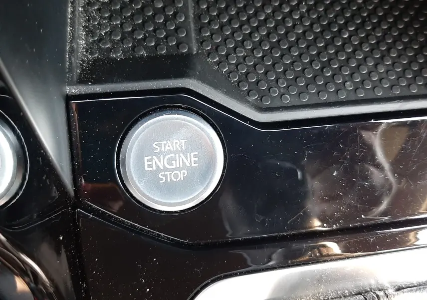 Gros plan sur le bouton Start Engine Stop dans l'habitacle noir brillant du Volkswagen T-Roc 2.0 TDI 150CH R-Line 2024.