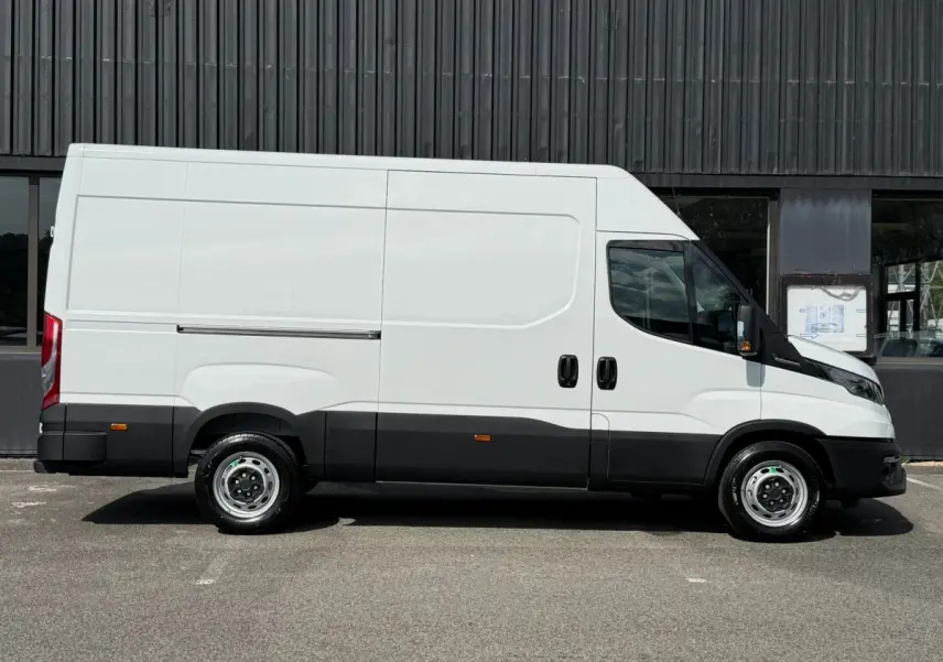Vue de profil côté gauche d’un fourgon Iveco Daily blanc avec bas de caisse noir, portes coulissantes et jantes acier.