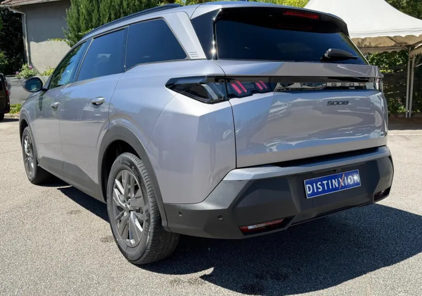 Vue 3/4 arrière droite du Peugeot 5008 gris clair 2025 avec feux arrière LED et vitres teintées.