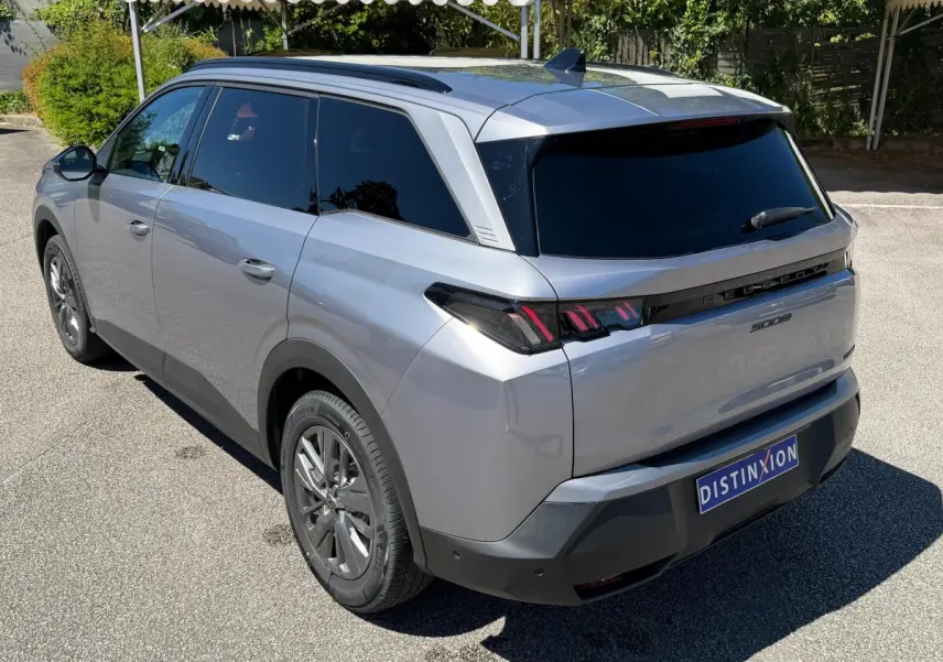 Vue 3/4 arrière droite du Peugeot 5008 gris clair, avec feux arrière LED et vitres teintées.