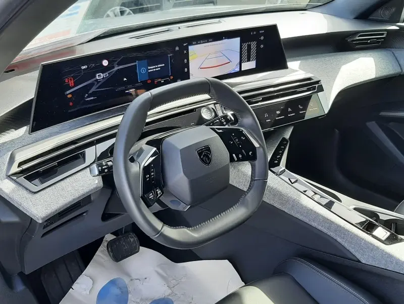 Vue intérieure avant droite du Peugeot 5008 gris clair, volant compact et double écran tactile large au tableau de bord.