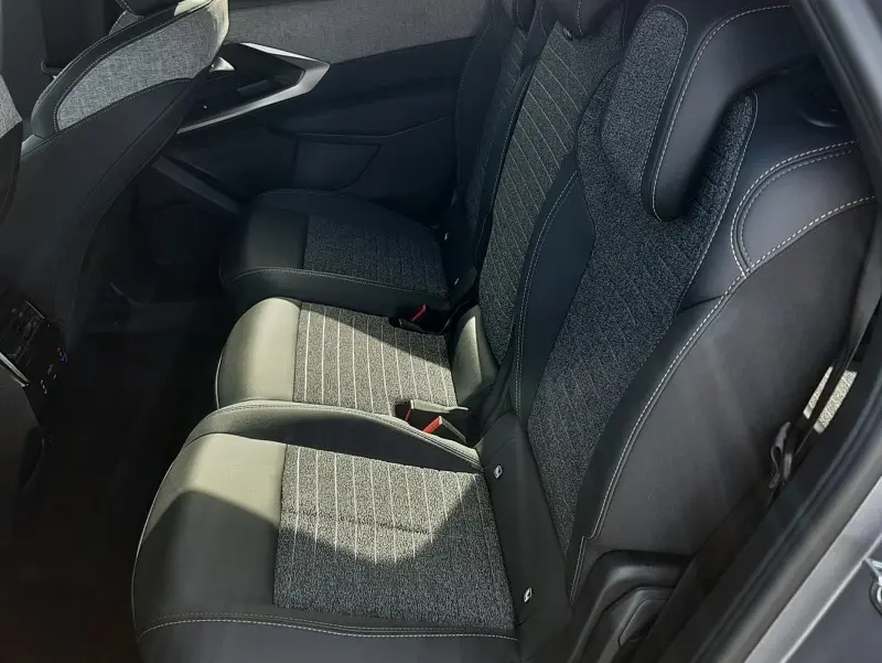 Vue intérieure côté droit sur la banquette arrière en tissu et cuir noir du Peugeot 5008 gris clair 2025.