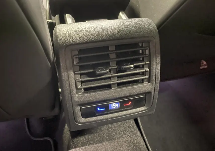 Détail de la console arrière noire avec diffuseur d'air et réglage numérique de la température à 19,5°C dans une Volkswagen Golf blanche.