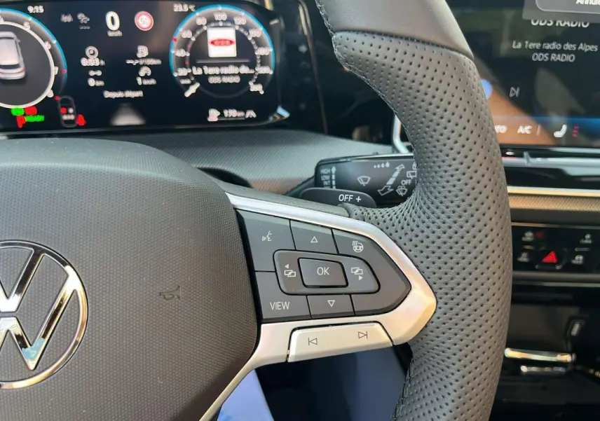 Gros plan sur le volant cuir perforé côté droit de la Volkswagen Golf E-TSI 150 R-Line avec affichage numérique.