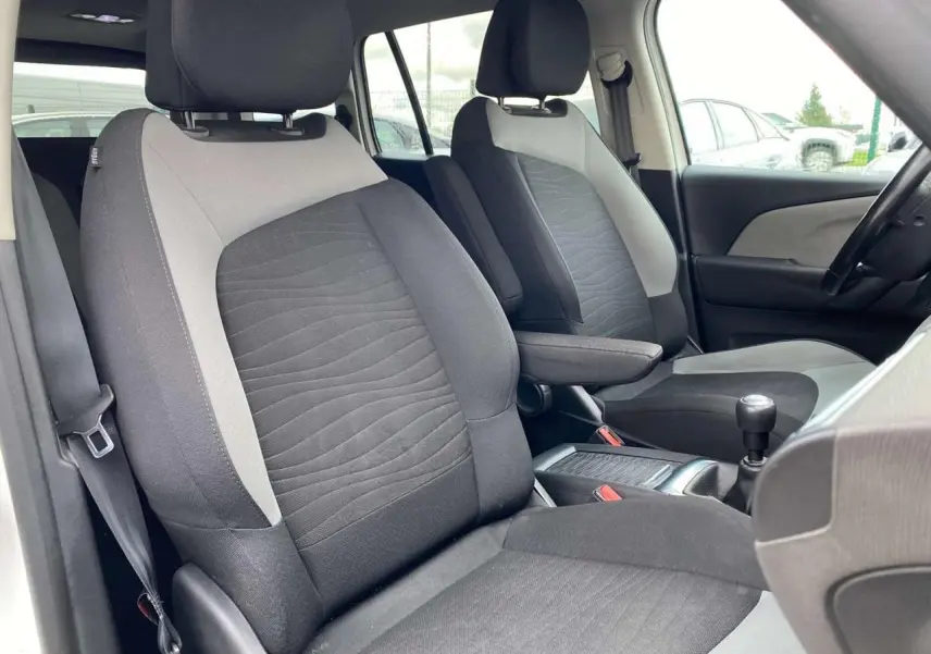 Vue intérieure rapprochée des sièges avant gris et noir du Citroën Grand C4 Picasso 2015, version Intensive.