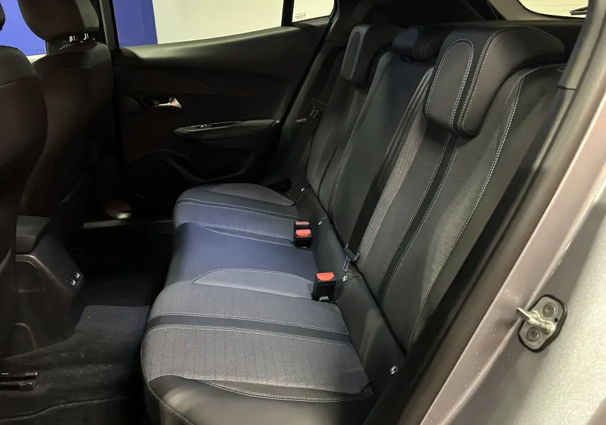 Vue intérieure côté droit des sièges arrière en tissu et cuir noir du Peugeot 2008 Gris Artense, avec ceinture de sécurité visible.