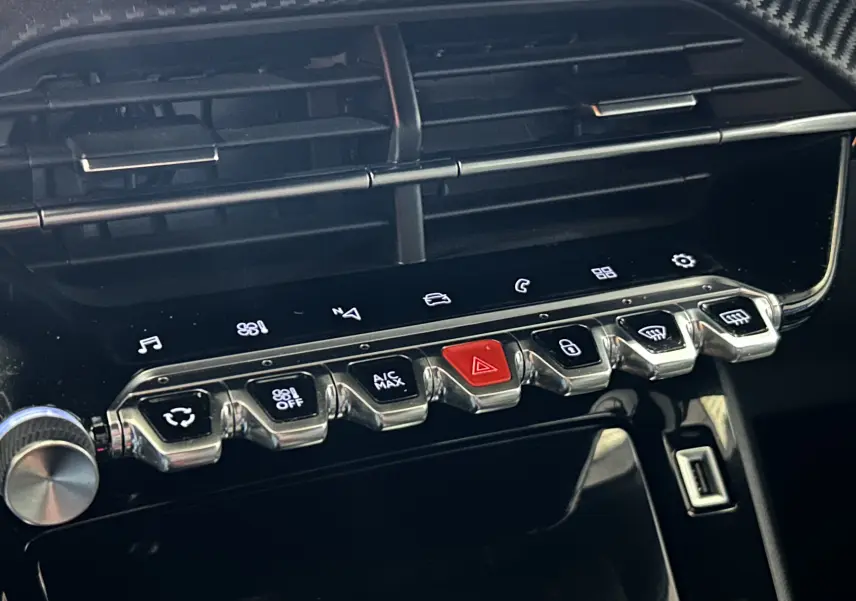 Gros plan sur la console centrale avec les boutons de commande et l'écran tactile du Peugeot 2008 gris Artense, intérieur moderne.