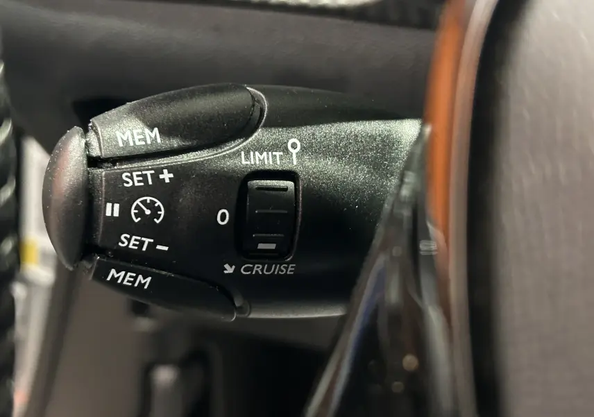 Gros plan sur la commande de régulateur de vitesse du Peugeot 2008 gris Artense, version Allure Pack 2023.
