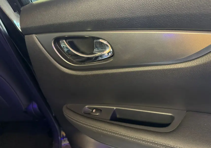 Poignée intérieure chromée et panneau de porte noir côté gauche du Nissan Qashqai II PH2 2017.