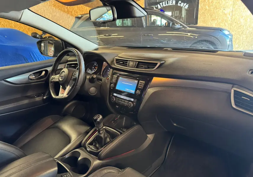 Intérieur noir du Nissan Qashqai II PH2 2017, vue côté conducteur avec volant cuir et console centrale manuelle.
