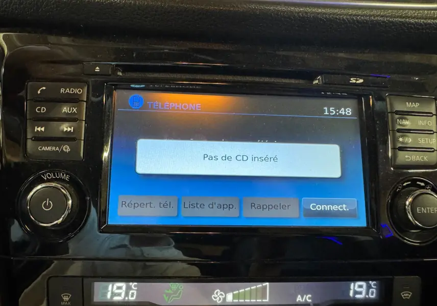 Écran tactile central du Nissan Qashqai noir, affichant le menu téléphone avec commandes autour en vue rapprochée.