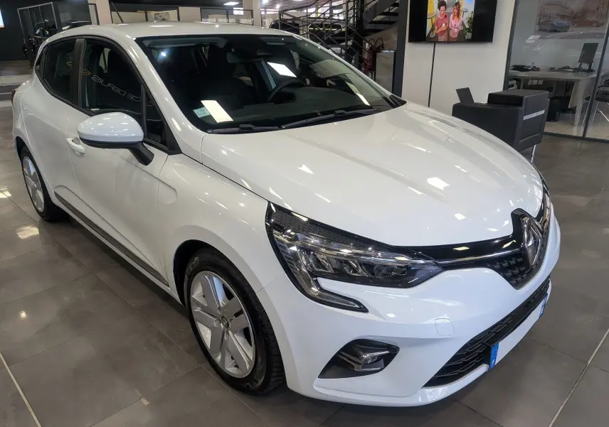 Renault Clio V Blue dCi 85 CH Business blanc glacier vue 3/4 avant droit en intérieur showroom.
