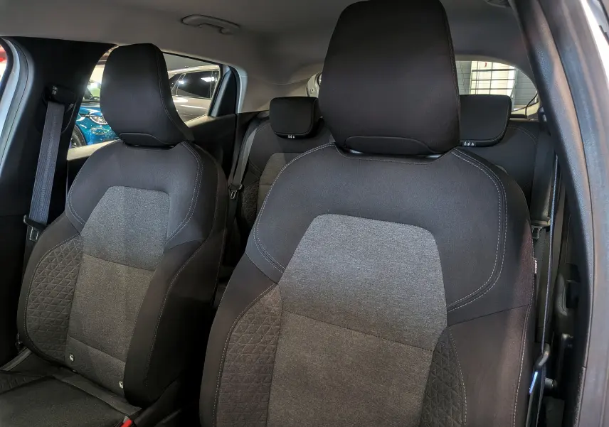 Vue intérieure rapprochée des sièges avant en tissu gris et noir de la Renault Clio V Business 2020.