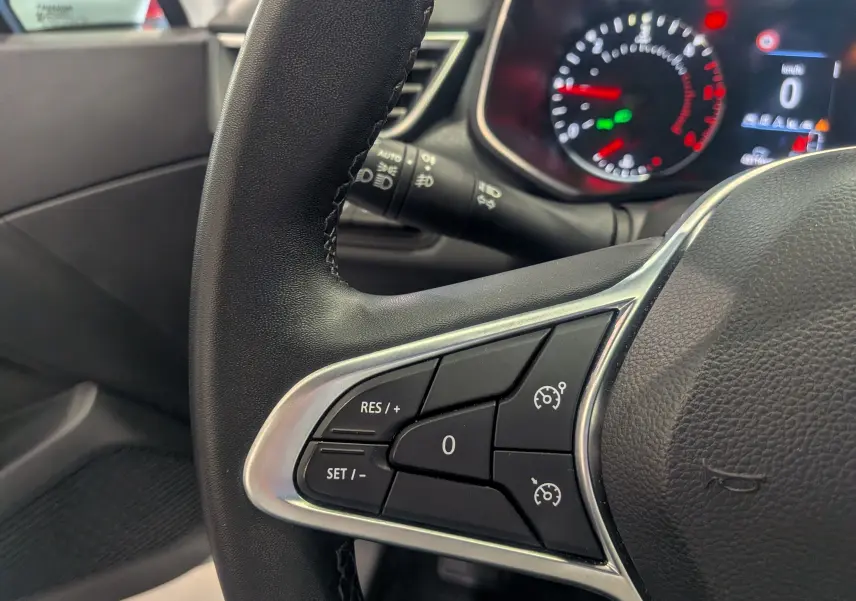 Gros plan sur le volant côté gauche de la Renault Clio V Business 2020, avec commandes de régulateur de vitesse visibles.