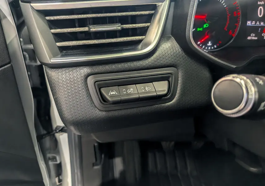 Vue intérieure côté gauche du tableau de bord de la Renault Clio V blanche, avec commandes d'assistance et ventilation visibles.
