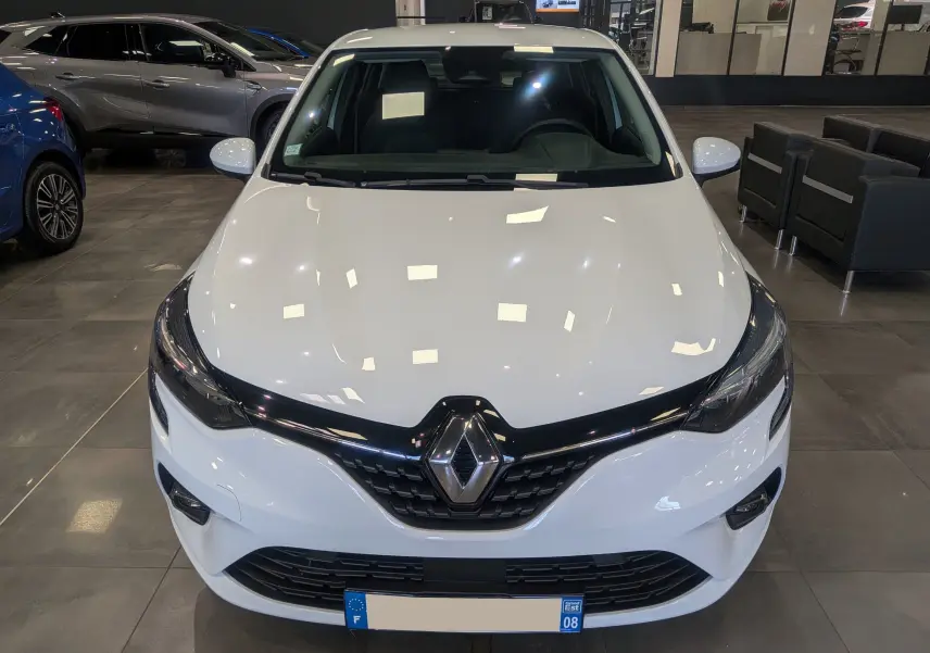 Vue avant d'une Renault Clio V Business blanche Glacier, avec calandre noire brillante et logo Renault central.
