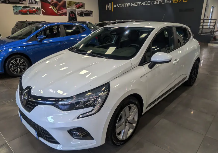 Renault Clio V Blue dCi 85 Business blanc glacier vue 3/4 avant droit en showroom avec jantes alliage.