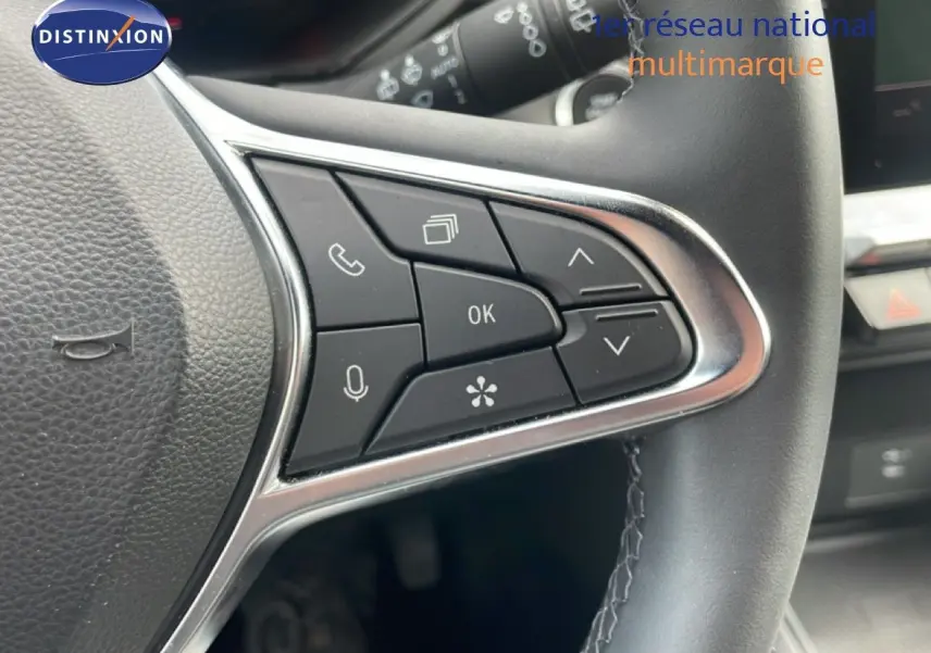 Gros plan sur les commandes multifonctions à droite du volant en cuir noir du Renault Captur 2025 gris Cassiopée métal.