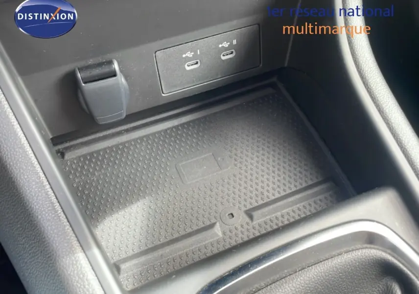 Gros plan sur la console centrale du Renault Captur 2025 montrant les ports USB et un espace de rangement noir.