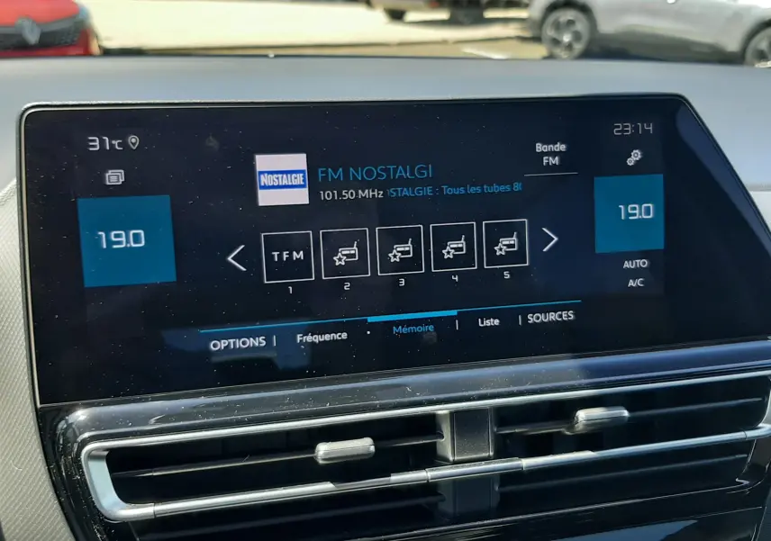 Vue intérieure centrée sur l’écran tactile multimédia du Citroën C5 Aircross noir, affichant la radio FM Nostalgie.
