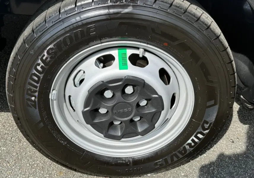 Gros plan sur la roue avant droite du Iveco Daily blanc 2026, pneu Bridgestone et jante acier grise avec cache central noir.