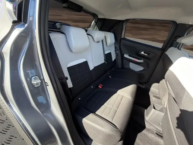 Vue intérieure arrière côté gauche de la Citroën C3 gris foncé 2025, montrant la banquette bicolore et les portes.