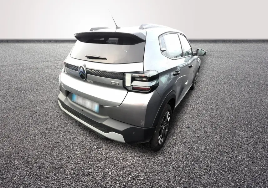 Vue 3/4 arrière droite d'une Citroën C3 Turbo 100 gris foncé avec spoiler de coffre et feux LED distinctifs.