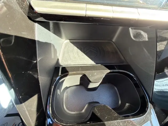 Gros plan sur la console centrale noire de la Citroën C3 Turbo 100 BVM6 MAX 2025, avec zone de recharge par induction et porte-gobelets.