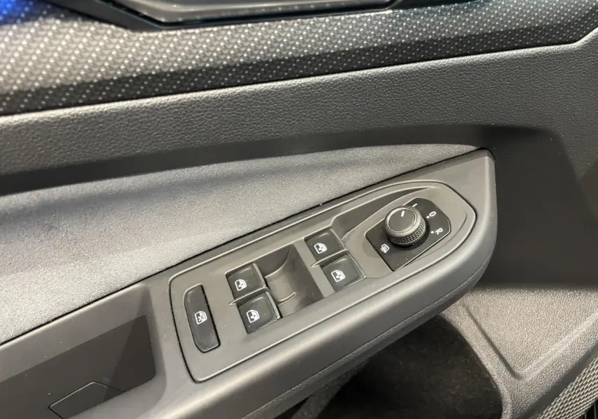 Détail des commandes de lève-vitres et réglage des rétroviseurs côté conducteur de la Volkswagen Golf VIII R-Line noire.
