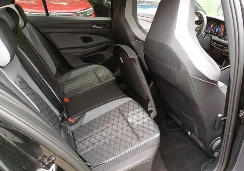 Vue intérieure côté gauche de la banquette arrière et des sièges avant en tissu noir et gris de la Volkswagen Golf VIII R-Line Black.