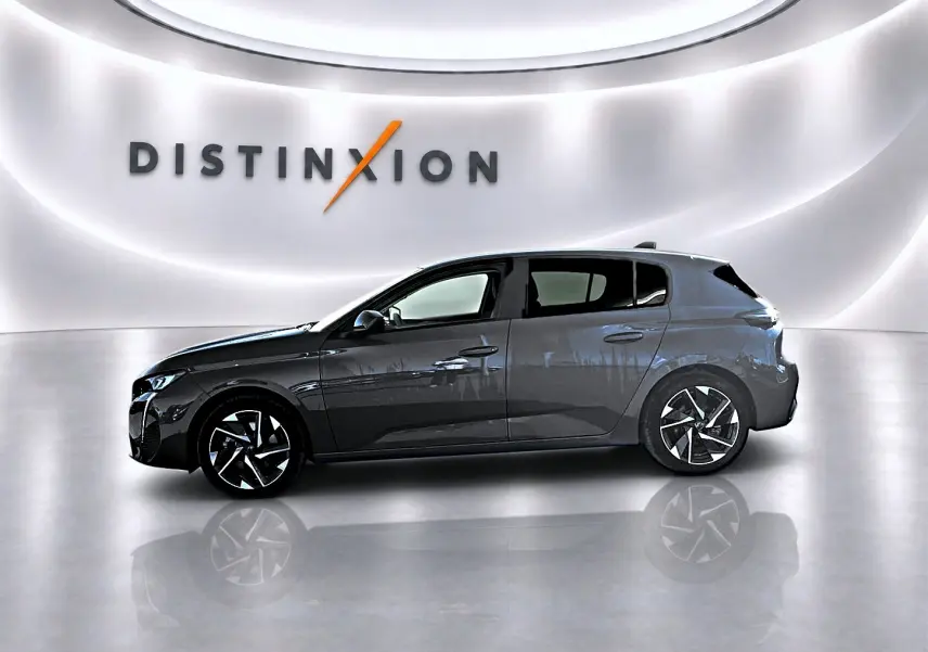 Profil gauche d'une Peugeot 308 gris selenium 2025 avec jantes alu et vitres arrière surteintées dans un showroom lumineux.