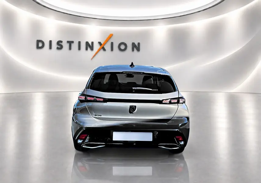 Vue arrière d'une Peugeot 308 gris selenium 2025 dans un showroom avec éclairage moderne et logo Distinxion.